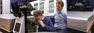 two people looking at a microscope 